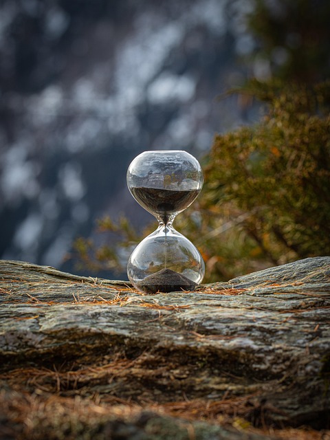 Hourglass sand timer resting on rocks
